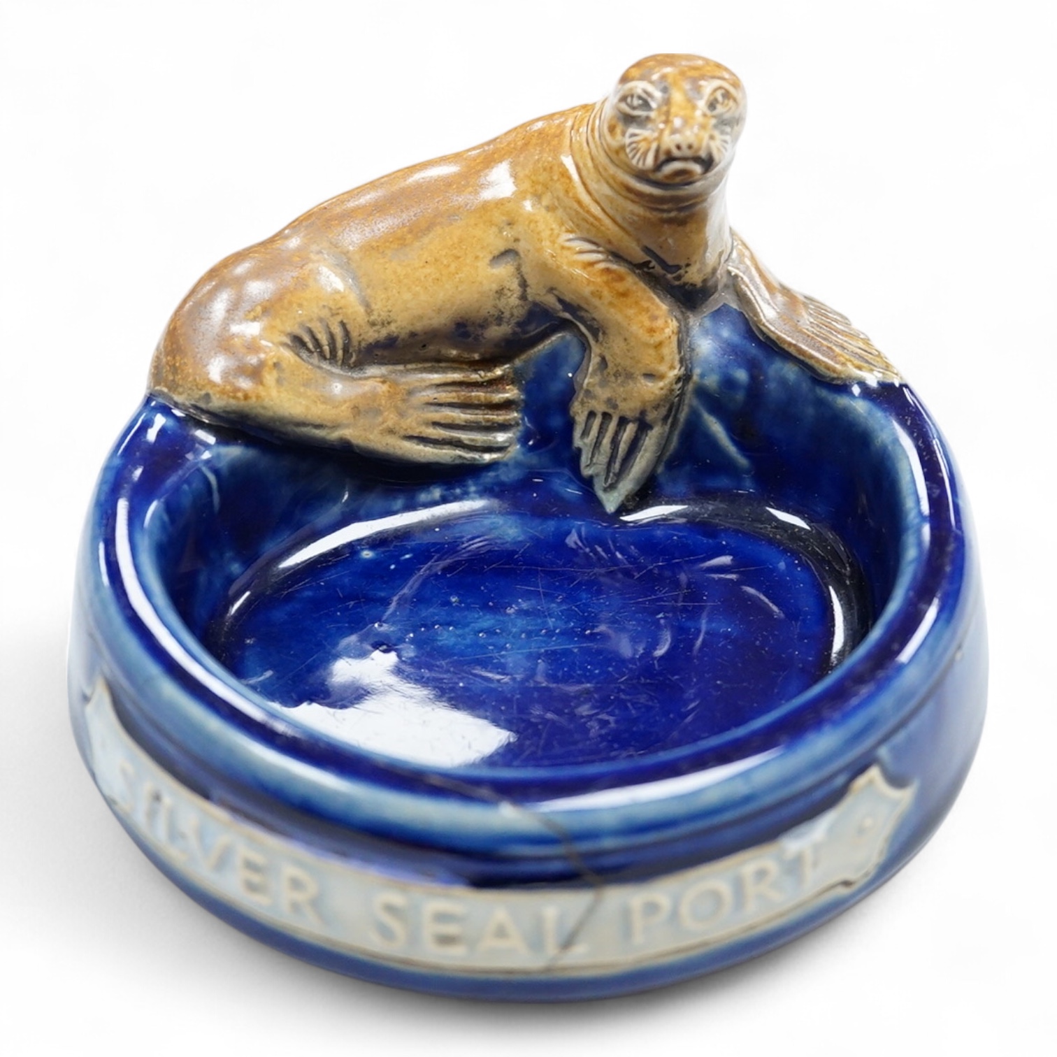 A Doulton ‘silver seal port’ advertising ashtray, 13cm wide (a.f)